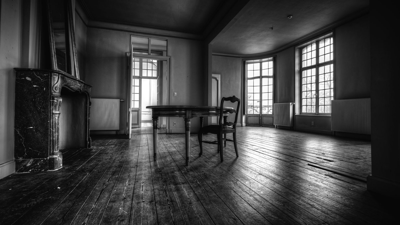 Lege kamer in een ouder huis met enkel nog een tafel en een stoel
